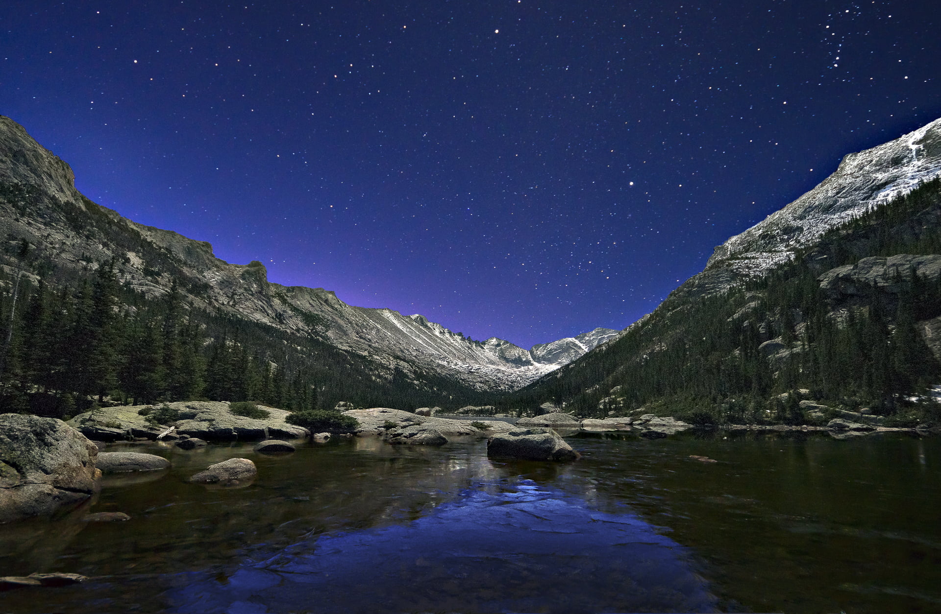 green and white mountain between the river during night