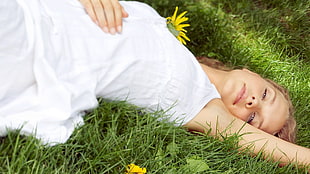woman in white tank dress lying on green grass field