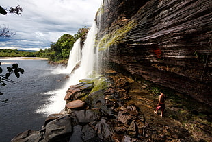 photo of man walking towards waterfalls, canaima, venezuela HD wallpaper