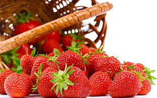 red strawberry on brown woven basket