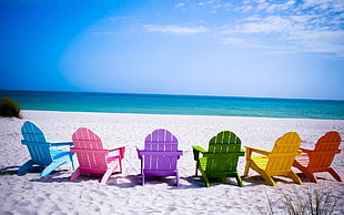 six assorted colored Adirondack chairs near seashore