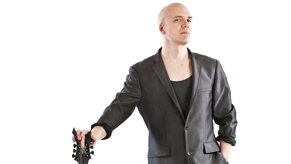 man wearing black formal coat holding guita HD wallpaper