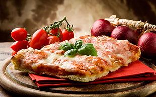 pizza on red table napkin beside vegetables