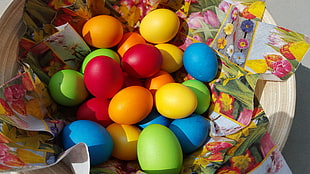 several colored eggs on multicolored floral textile