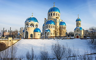 brown and blue cathedral surrounded by snow under blue and white sky during daytime