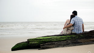 men's blue top, beach, rock, sitting, couple