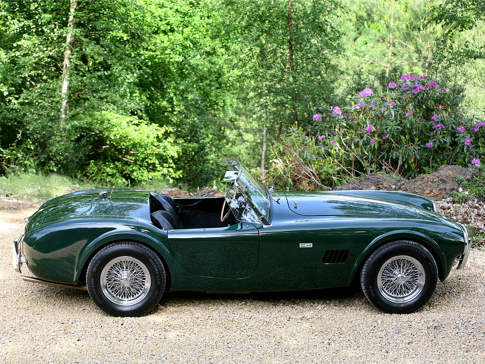 green classic convertible coupe parked on grey pavement HD wallpaper