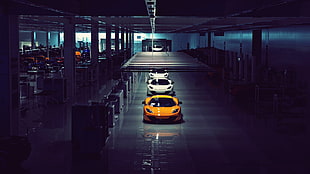 three white and yellow sports coupes in building