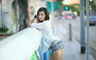 woman in white dress shirt posing beside metal railings HD wallpaper