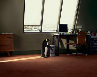 penguin near gray computer tower and window