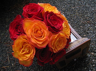 red and orange artificial flowers on brown wooden box