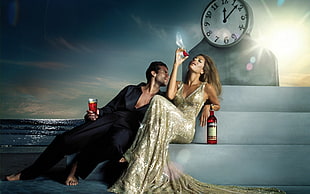 man and woman sitting on strain drinking wine near clock