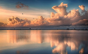 asymmetrical view of calm body of water under clouds