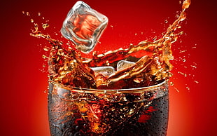 ice cubes dropping on glass of beverage