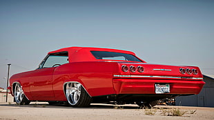 classic red coupe parked on concrete pavement HD wallpaper