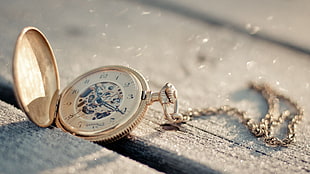shallow focus of gold-colored pocket watch