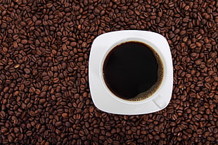 coffee in white cup on ceramic saucer with full of coffee beans HD wallpaper