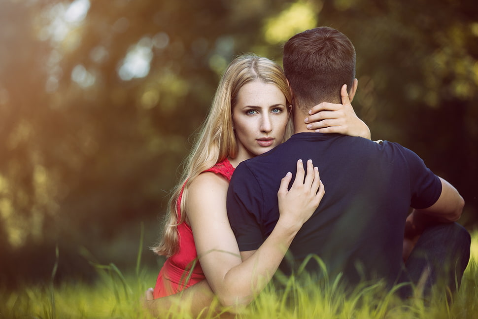 man and woman sitting on grass HD wallpaper
