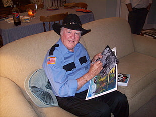 man in blue police suit sitting on sofa
