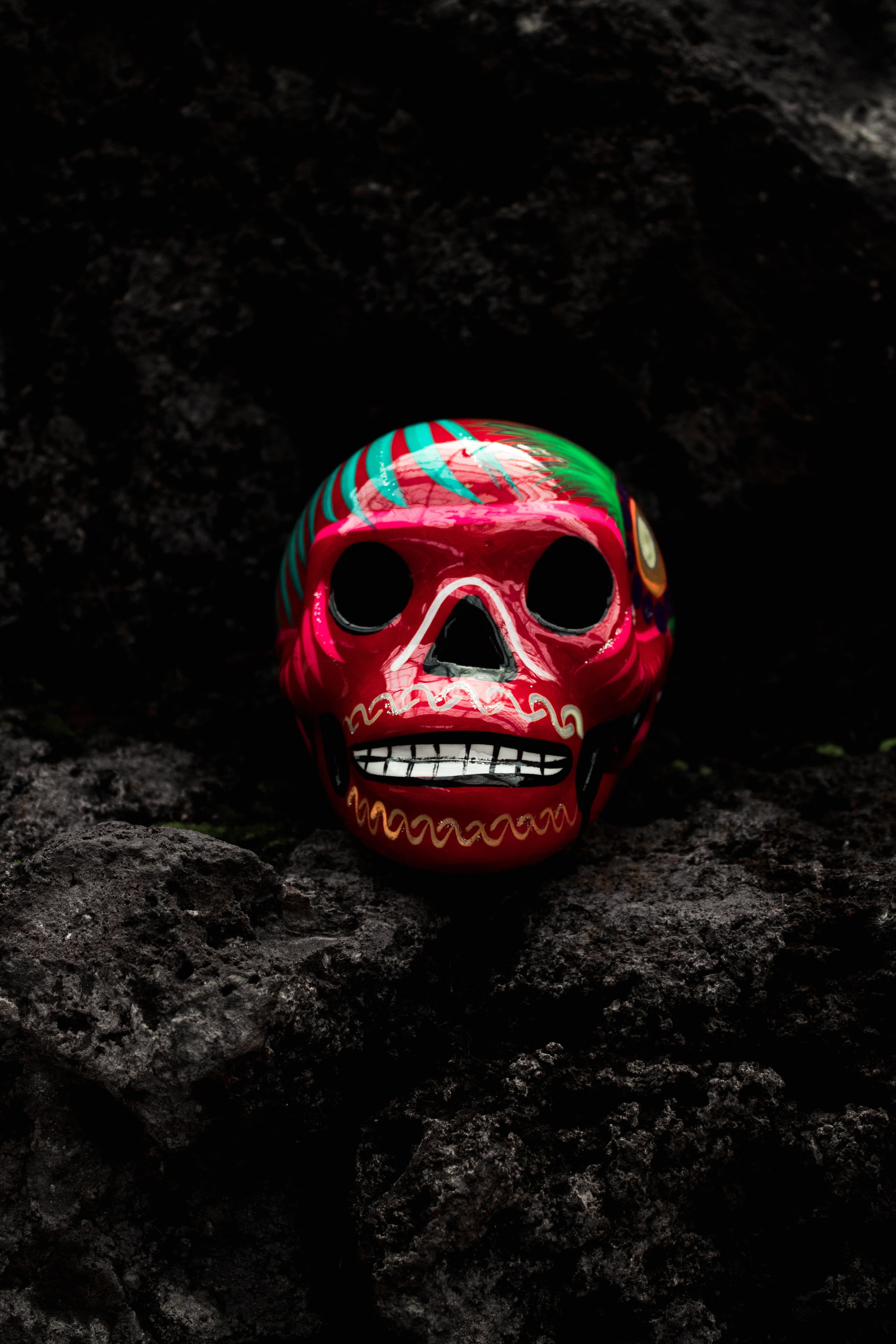red, green, and teal decorative skull