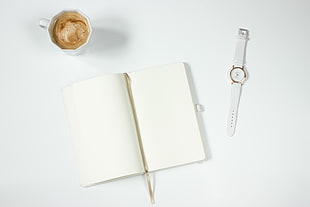 high angle photography of opened notebook in middle of watch and coffee