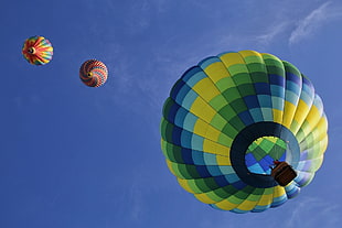 three assorted hot-air balloons under clear blue sky