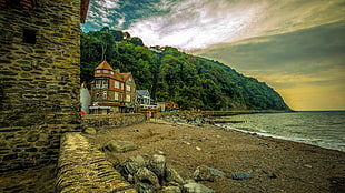 brown house on shore at golden hour