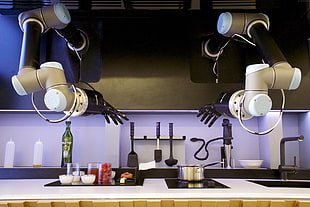 robotic hands in front of kitchen with utensils