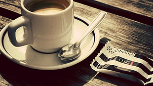 white ceramic mug and stainless steel spoon on saucer