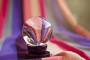 crystal ball on top of assorted color of textile