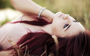 woman lying on green grass field photography