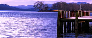 brown wooden deck in body of water at sunrise, bluebird, coniston water