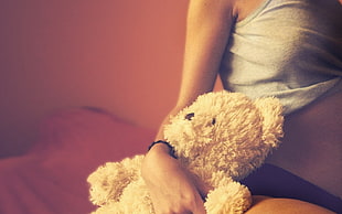person holding brown teddy bear photo