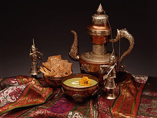 middle eastern tea pot with two round bowls and two soldier figurines on table