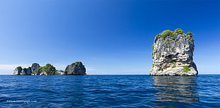 photo of island on ocean during day tiome