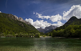 landscape photo of body of water with green mountains