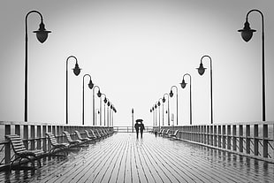 gray scale photo of two person holding umbrella