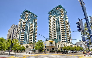 two blue and brown high rise buildings under blue sky