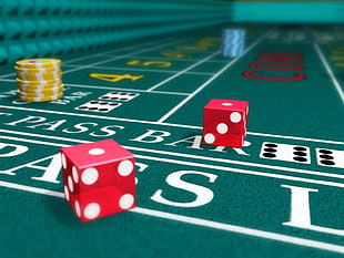 closeup photo of two red dice on green board