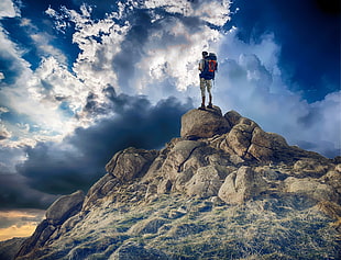man standing on rocks in mountain during daytime