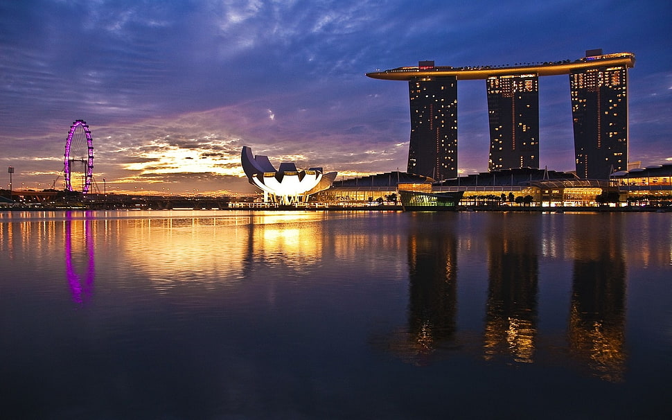 concrete building with light up glow under cloudy sky during dawn HD wallpaper