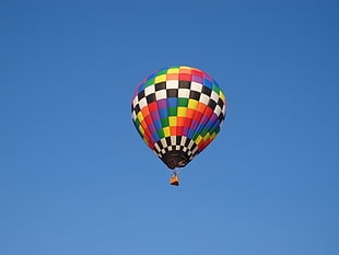 rainbow-colored checkered hot air balloon floating at daytime