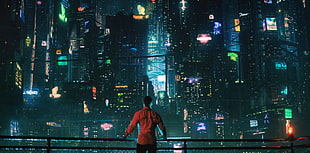 man facing lighted buildings movie still