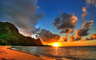 Sunset on beach beside mountain HD wallpaper