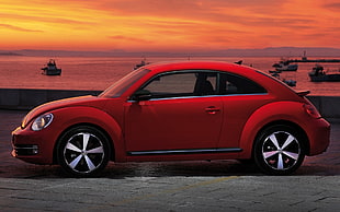 new red Volkswagen Beetle park beside sea HD wallpaper