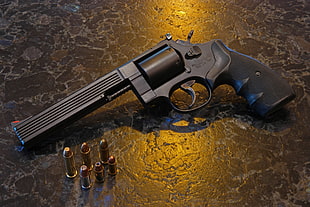 close up photo of black revolver pistol and bullets