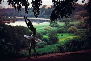 woman in ballerina dress near grass field during daytime