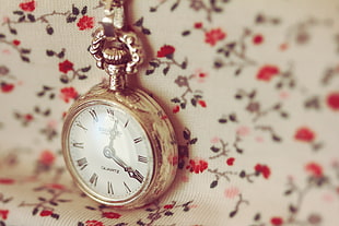 selective focus photography of round gold-colored pocket watch