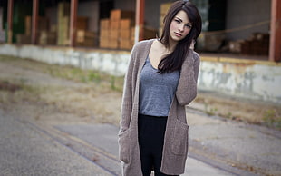 woman in grey top with grey cardigan standing on road