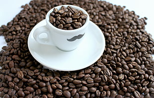 coffee beans with white ceramic mug and saucer